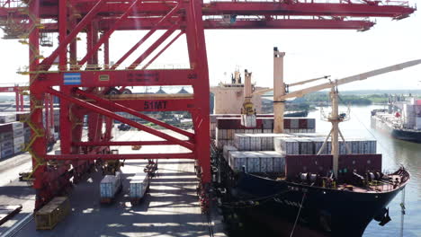 panoramic-drone-shot-of-forklift-loading-a-container,-customs