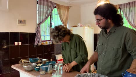Prepare-food-grind-cardamom-seeds-aroma-for-baking-delicious-bread-persian-flat-bread-in-clay-oven-in-rural-area-town-village-in-Iran-healthy-couple-life-working-together-at-home-curly-hair-woman-man