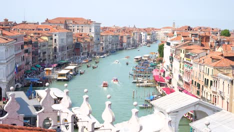 Grand-canal-of-Venice-with-boats,-gondolas-and-picturesque-houses-seen-from-Fondaco-dei-Tedeschi-rooftop