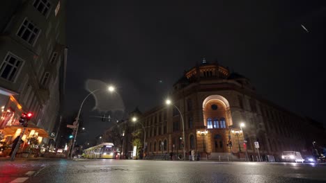 timelapse-of-Oranienburger-Strasse-and-Tucholskystr-intersection-with-busy-traffic-moving-in-a-winter-night-with-light-snowfall