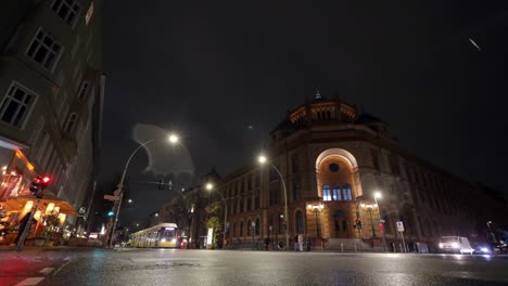 Timelapse-De-La-Intersección-De-Oranienburger-Strasse-Y-Tucholskystr-Con-Tráfico-Intenso-En-Una-Noche-De-Invierno-Con-Nevadas-Ligeras