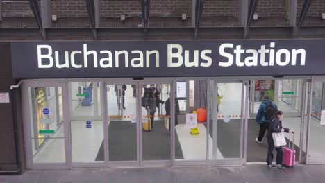 People-entering-and-exiting-Buchanan-Bus-Station,-Glasgow,-Scotland