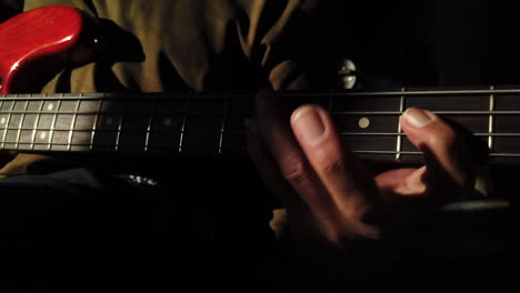 Man-playing-bass-guitar-showing-left-hand-finger-technique