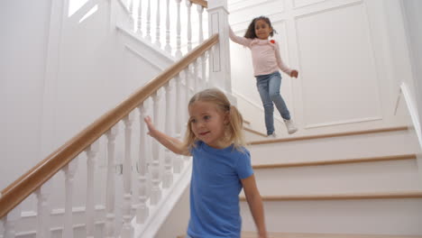 Zwei-Mädchen,-Die-Die-Treppe-Hinunterrennen,-Wurden-In-Zeitlupe-Aufgenommen