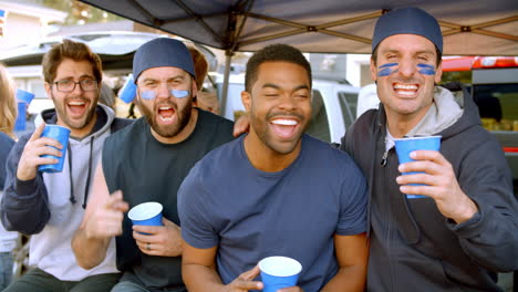 Group-Of-Male-Sports-Fans-Tailgating-In-Stadium-Parking-Lot