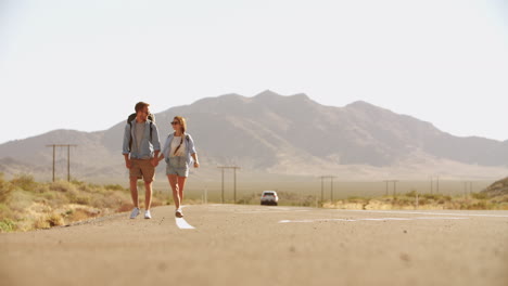 Couple-On-Vacation-Hitchhiking-Along-Road-Shot-On-R3D