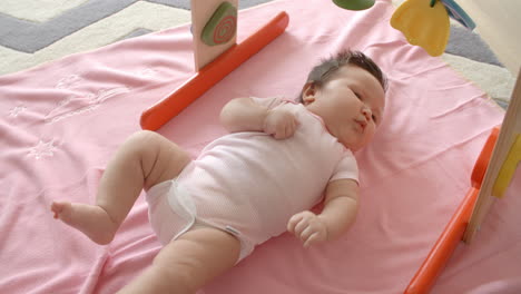 Baby-Girl-Laying-On-Pink-Blanket-Shot-In-Slow-Motion