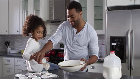 Black-dad-and-young-daughter-prepare-cakes-for-baking,-shot-on-R3D