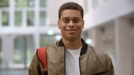 Estudiante-Universitario-Masculino-Caminando-Hacia-El-Foco-En-Un-Vestíbulo-Moderno