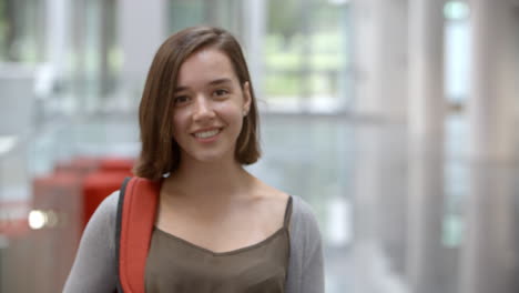 White-female-university-student-walking-into-focus-indoors