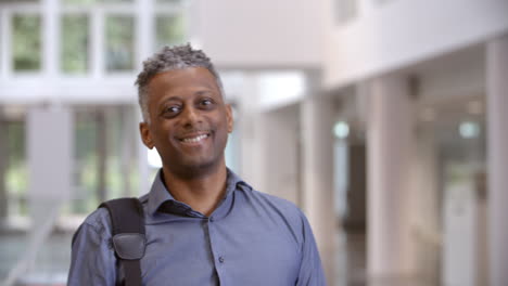 Middle-aged-black-male-teacher-walking-into-focus-in-a-lobby