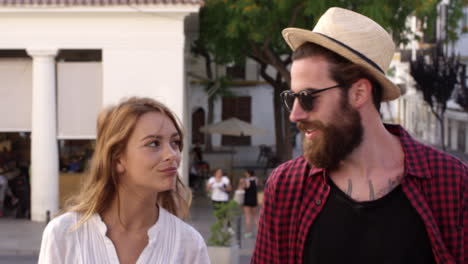 Couple-on-vacation-talking-as-they-walk-through-Ibiza-town,-shot-on-R3D