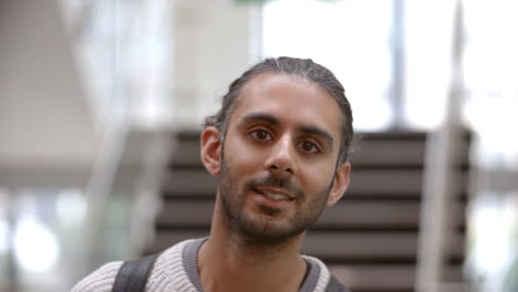 Asian-male-university-student-walking-into-focus-indoors