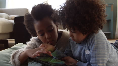 Dos-Niños-Jugando-Con-Una-Tableta-Digital-En-Casa-Filmada-En-R3d