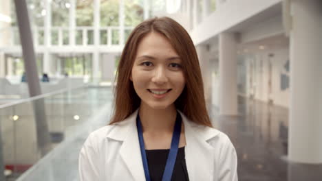 Portrait-Of-Smiling-Female-Doctor-In-Lobby-Of-Hospital