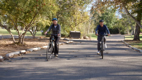 Senior-Couple-Cycling-Through-Park-In-Slow-Motion