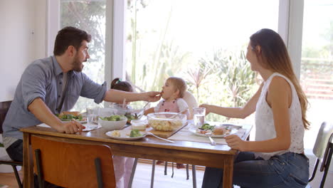 Family-Enjoying-Meal-At-Home-Together-Shot-In-Slow-Motion