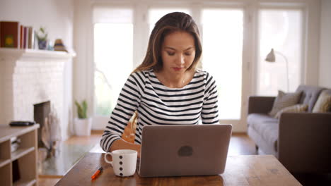 Woman-Working-From-Home-Using-Laptop-On-Dining-Table