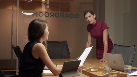 Two-businesswomen-working-late-talking-in-an-office,-close-up-shot-on-R3D