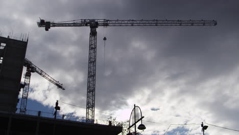 Silhouette-Of-Tower-Cranes-On-Construction-Site