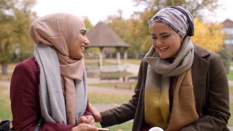 Dos-Mujeres-Musulmanas-Británicas-Reunidas-En-El-Parque-Urbano.