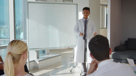 Doctor-Making-Presentation-To-Medical-Staff-In-Hospital