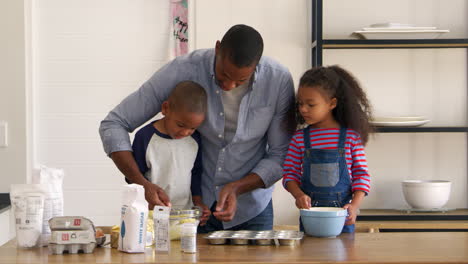 Father-And-Children-Baking-Cakes-In-Kitchen-Together