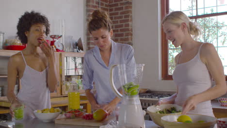 Three-female-friends-making-smoothies-in-kitchen,-shot-on-R3D