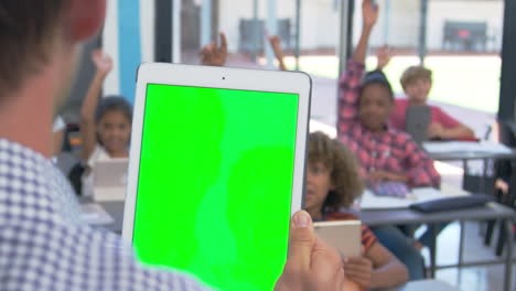 Teacher-using-tablet-in-school-class,-over-shoulder-view