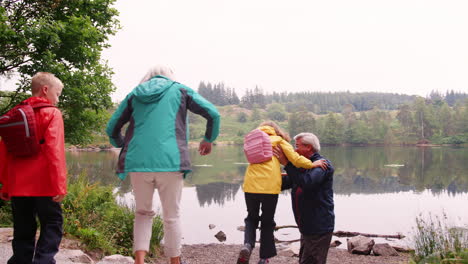 Großeltern-Und-Enkelkinder-Haben-Spaß-Beim-Spielen-An-Einem-See,-Lake-District,-Großbritannien