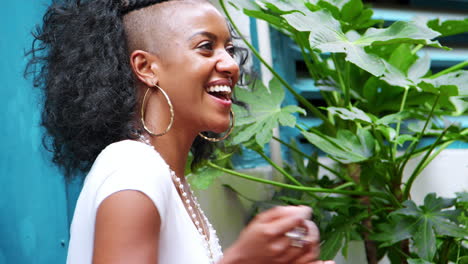 Fashionable-happy-young-black-woman-sitting-outdoors-talking-and-smiling,-close-up