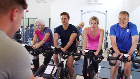 Trainer-Taking-Spin-Class-In-Gym