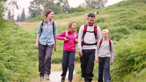 Parents-and-children-walking-on-a-countryside-path-during-a-family-camping-holiday,-Lake-District,-UK