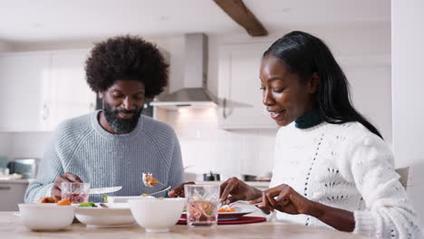 Happy-black-couple-talking-and-enjoying-their-Sunday-dinner-together-at-home,-close-up