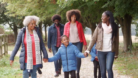 Familia-Multigeneracional-En-Otoño-Caminan-Juntos-En-El-Campo