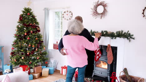 Back-view-of-senior-black-couple-dancing-in-their-living-room,-decorated-for-Christmas,-three-quarter-length-view,-handheld