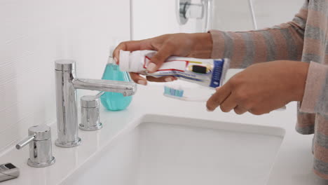 Close-Up-Of-Woman-Squeezing-Toothpaste-Onto-Toothbrush-In-Bathroom