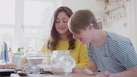Young-Downs-Syndrome-Couple-Measuring-Ingredients-To-Bake-Cake-In-Kitchen-At-Home