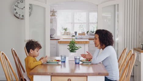 Alleinerziehende-Mutter-Sitzt-Am-Tisch-Und-Isst-Mit-Ihrem-Sohn-In-Der-Heimischen-Küche
