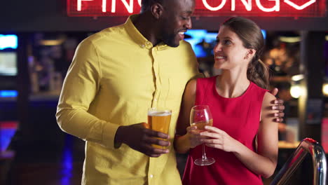 Couple-Climbing-Stairs-As-They-Meet-For-Drinks-And-Socialize-In-Bar