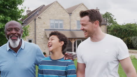 Father-With-Son-And-Grandfather-From-Multi-Generation-Mixed-Race-Family-Walking-In-Garden-At-Home