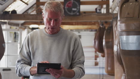 Senior-Male-Boxing-Coach-In-Gym-Tracking-Training-Using-Digital-Tablet