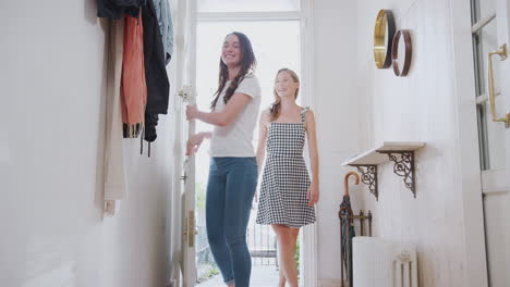 View-Inside-Hallway-As-Same-Sex-Female-Couple-With-Daughter-Open-Front-Door-Of-Home