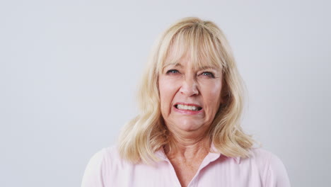 Studio-Shot-Of-Excited-Mature-Woman-Against-White-Background-At-Camera