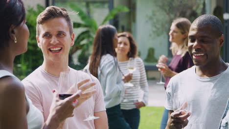 Group-Of-Multi-Cultural-Friends-Relaxing-And-Drinking-Wine-In-Garden-Together