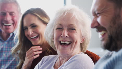 Ältere-Eltern-Mit-Erwachsenen-Nachkommen-Sitzen-Zu-Hause-Auf-Dem-Sofa-Und-Reden-Und-Lachen
