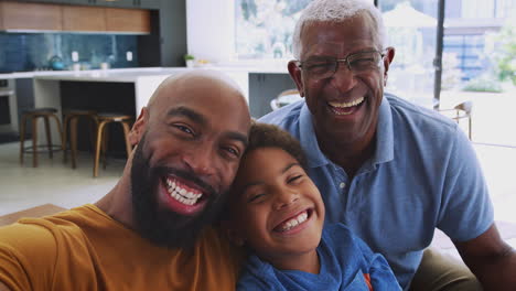 Portrait-Of-Smiling-Multi-Generation-Male-African-American-Family-Sitting-On-Sofa-At-Home