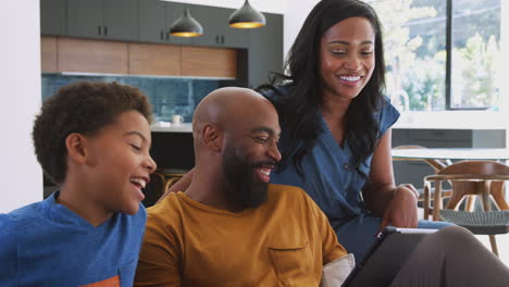 Afroamerikanische-Familie-Mit-Sohn,-Der-Zu-Hause-Auf-Dem-Sofa-Sitzt-Und-Ein-Digitales-Tablet-Nutzt