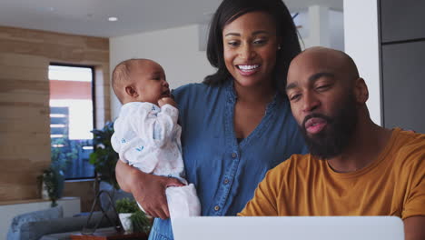 Afroamerikanische-Familie-Mit-Kleiner-Tochter,-Die-Zu-Hause-Einen-Laptop-Benutzt,-Um-Ihre-Finanzen-Zu-überprüfen