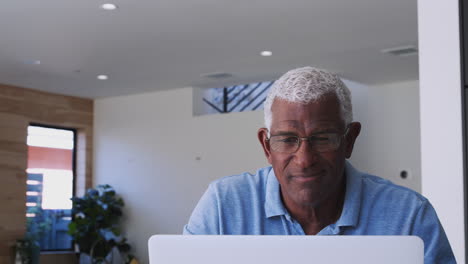 Hombre-Afroamericano-De-Alto-Rango-Usando-Una-Computadora-Portátil-Para-Verificar-Las-Finanzas-En-Casa